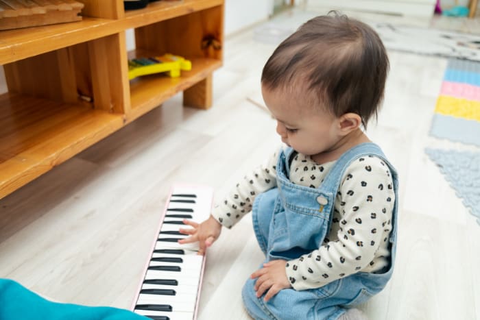 Toddler playing with toy piano