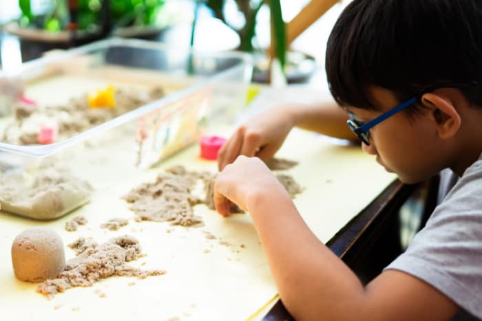 Young boy playing with kinetic sands