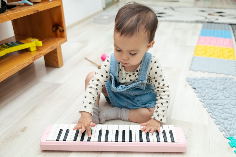 toddler playing a toy piano