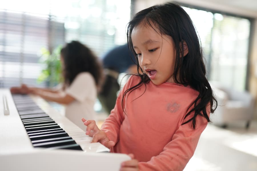 young girl practicing on the piano